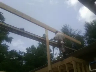 Carpenter setting a ridge beam over a new addition frame — Ice Dam Removal by Roofing Brothers in Hawk Springs