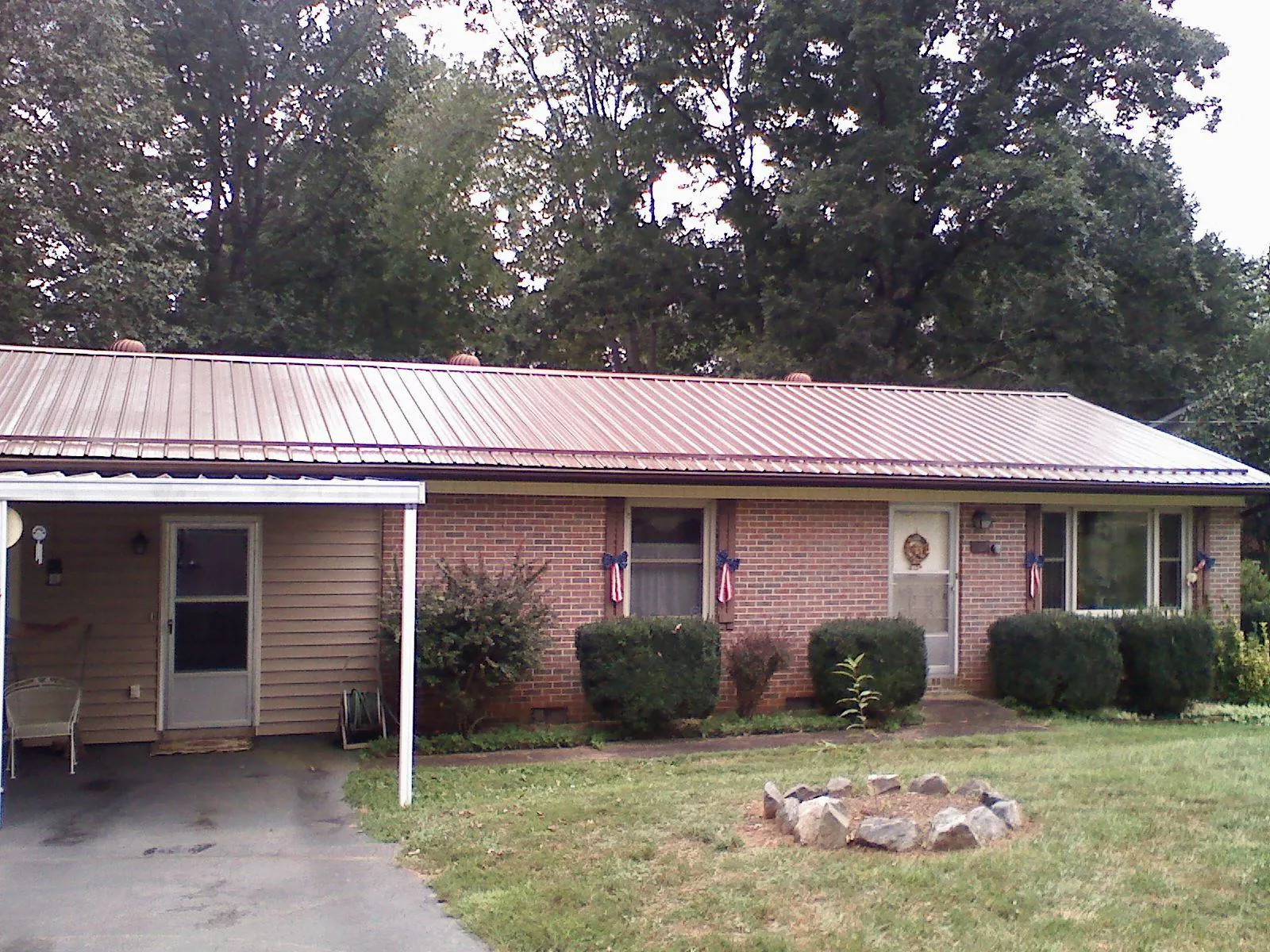 Bronze metal roof and carport on a brick ranch home — Roof Repair work by our crew in Hawk Springs