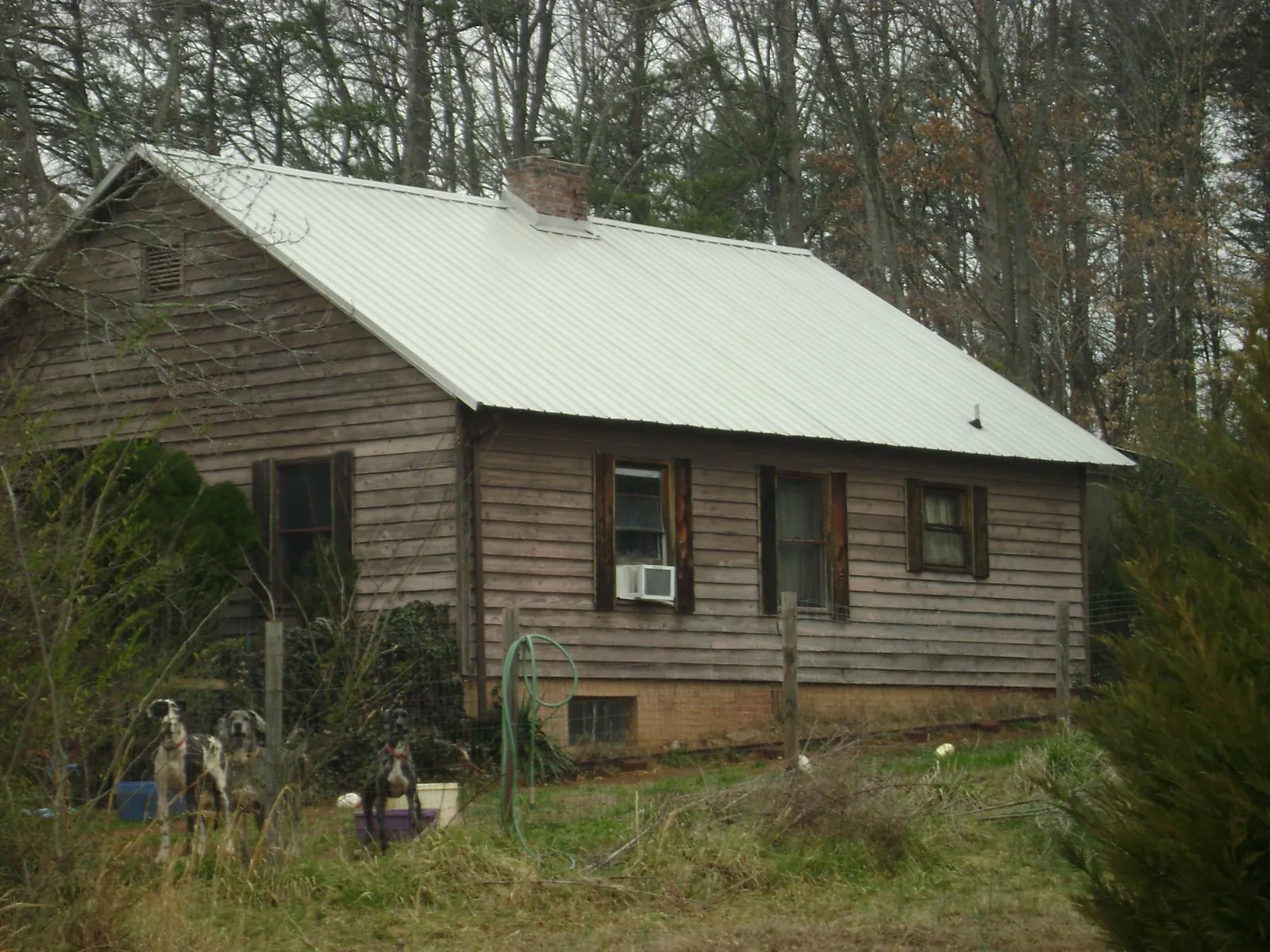 White metal roof on an old wood sided farmhouse, from a Asphalt Shingle Roof Repair job in Hawk Springs